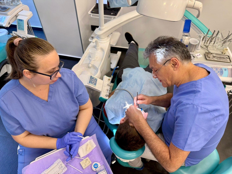 Doktor i sestra u ortodontskoj ordinaciji postavljaju ortodontski fiksni aparat